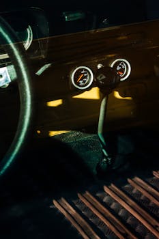 A detailed view of a classic car's interior highlighting the vintage gear shifter and dashboard dials.