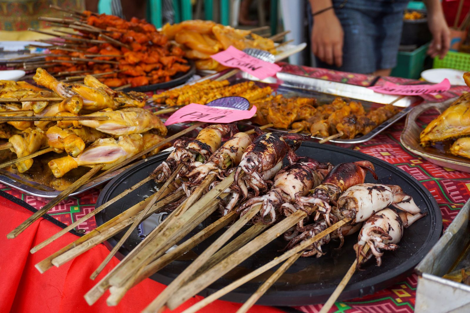 Display of skewered seafood and meats at a traditional Filipino street food market in Iloilo City