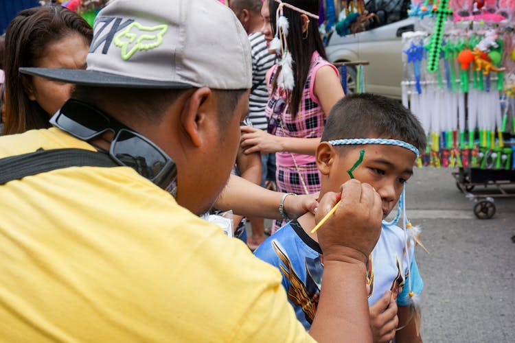 Man Painting Boy Face