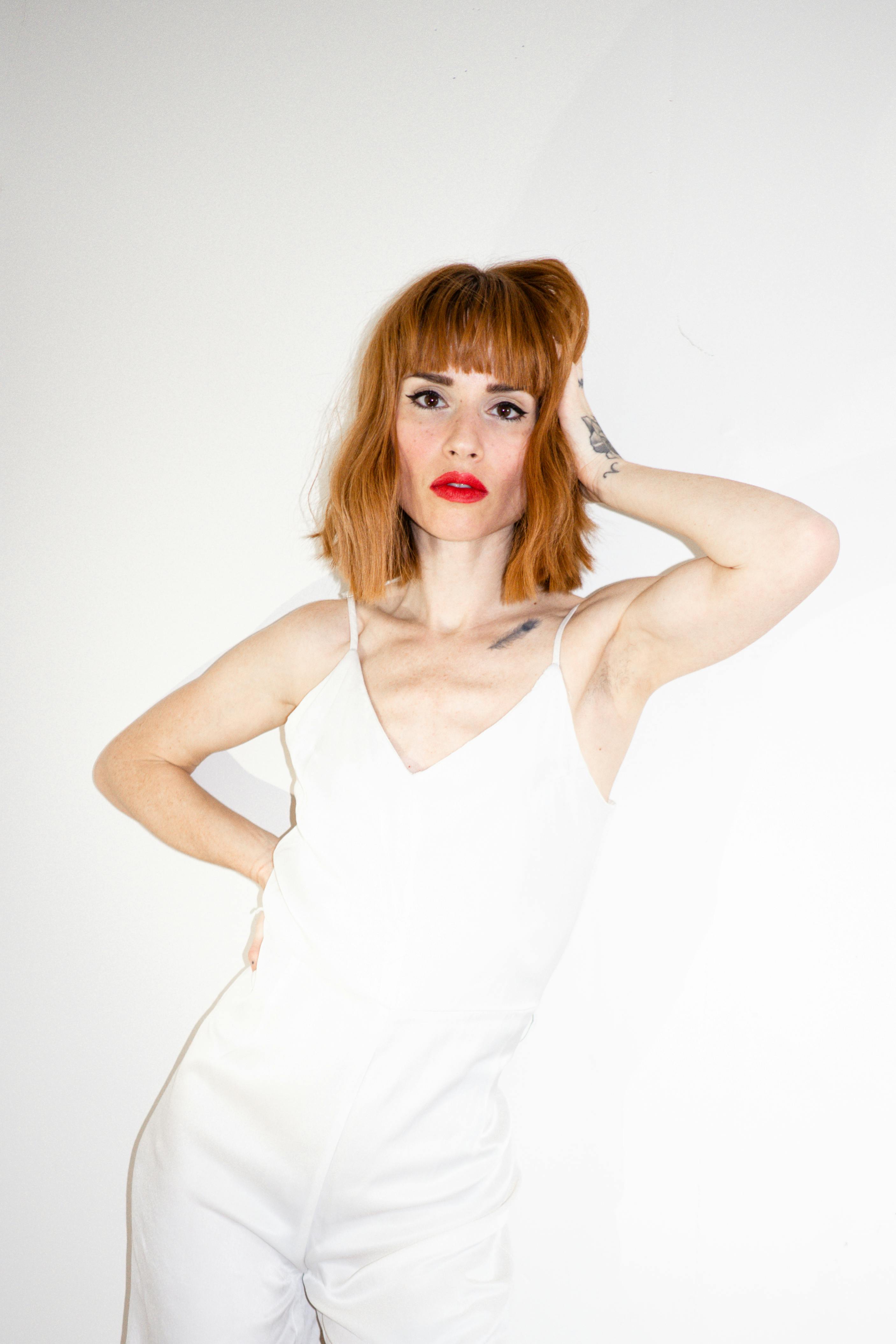 一幅引人注目的红发女子白衣肖像，展现优雅的时尚风格