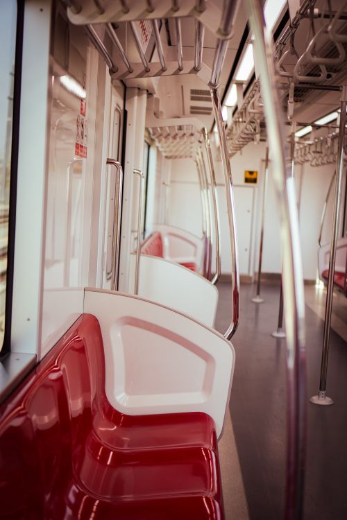 Free Explore the sleek and modern interior of a city subway train, featuring empty red seats and clean lines. Stock Photo
