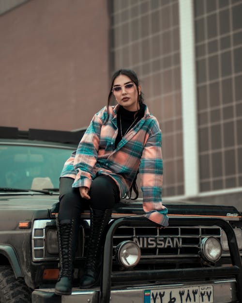 Female Model Sitting on the Hood of an Off-Road Car