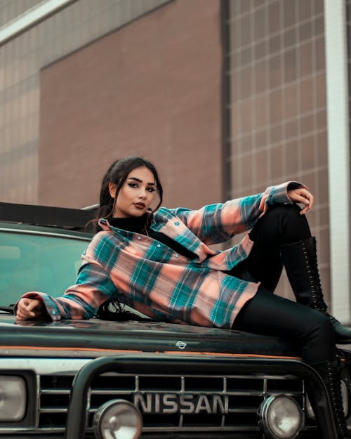 Female Model Lying on the Hood of an Off-Road Car
