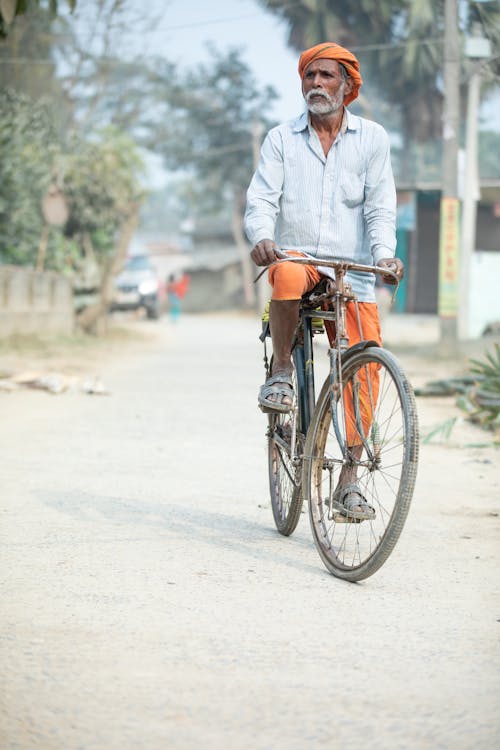 Elderly Man on Bike in Village