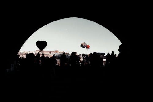 Silhouettes of People Standing in a Dark Tunnel