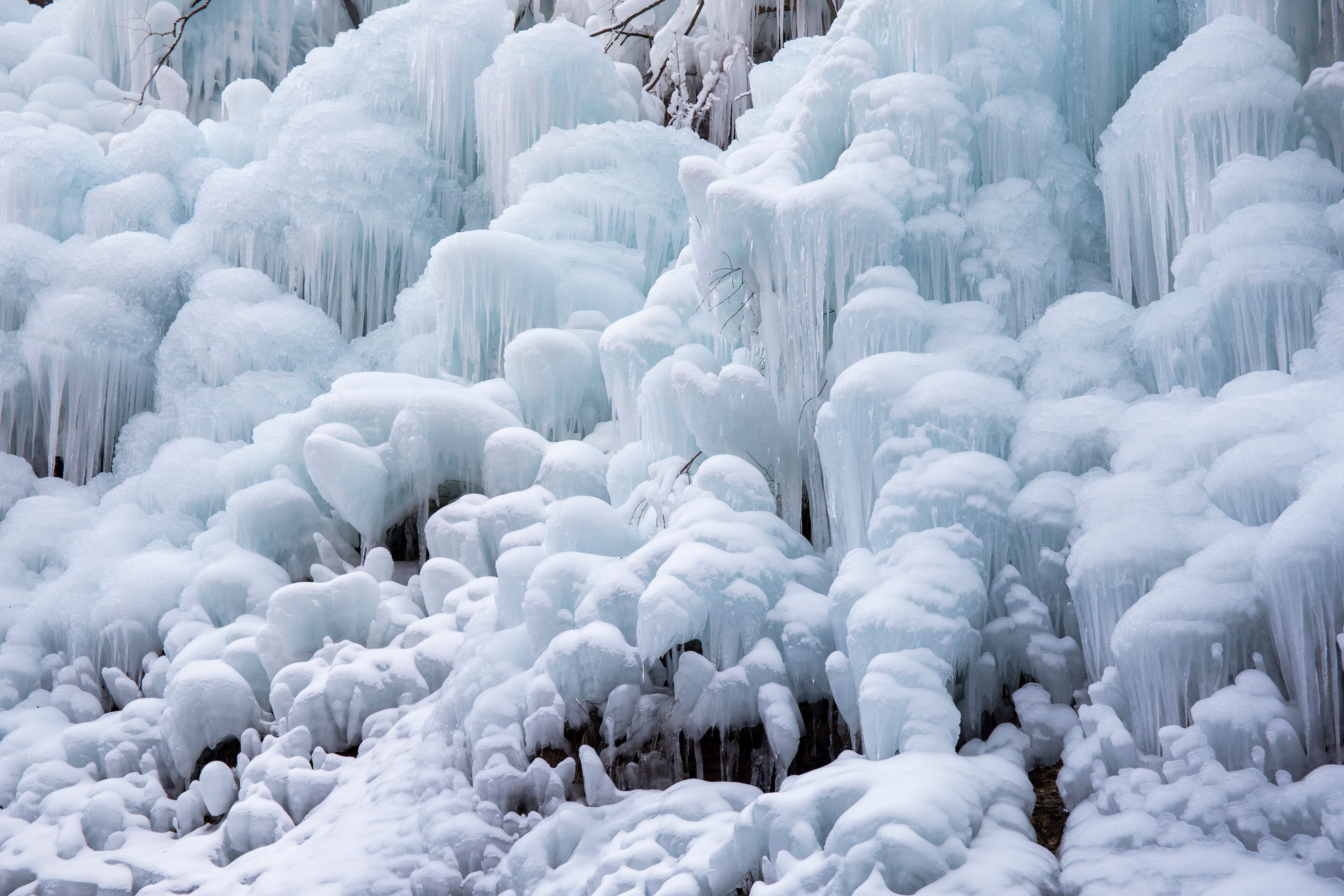 Bottles of vodka and whiskey sitting in a frosty freezer with ice crystals forming on the glass