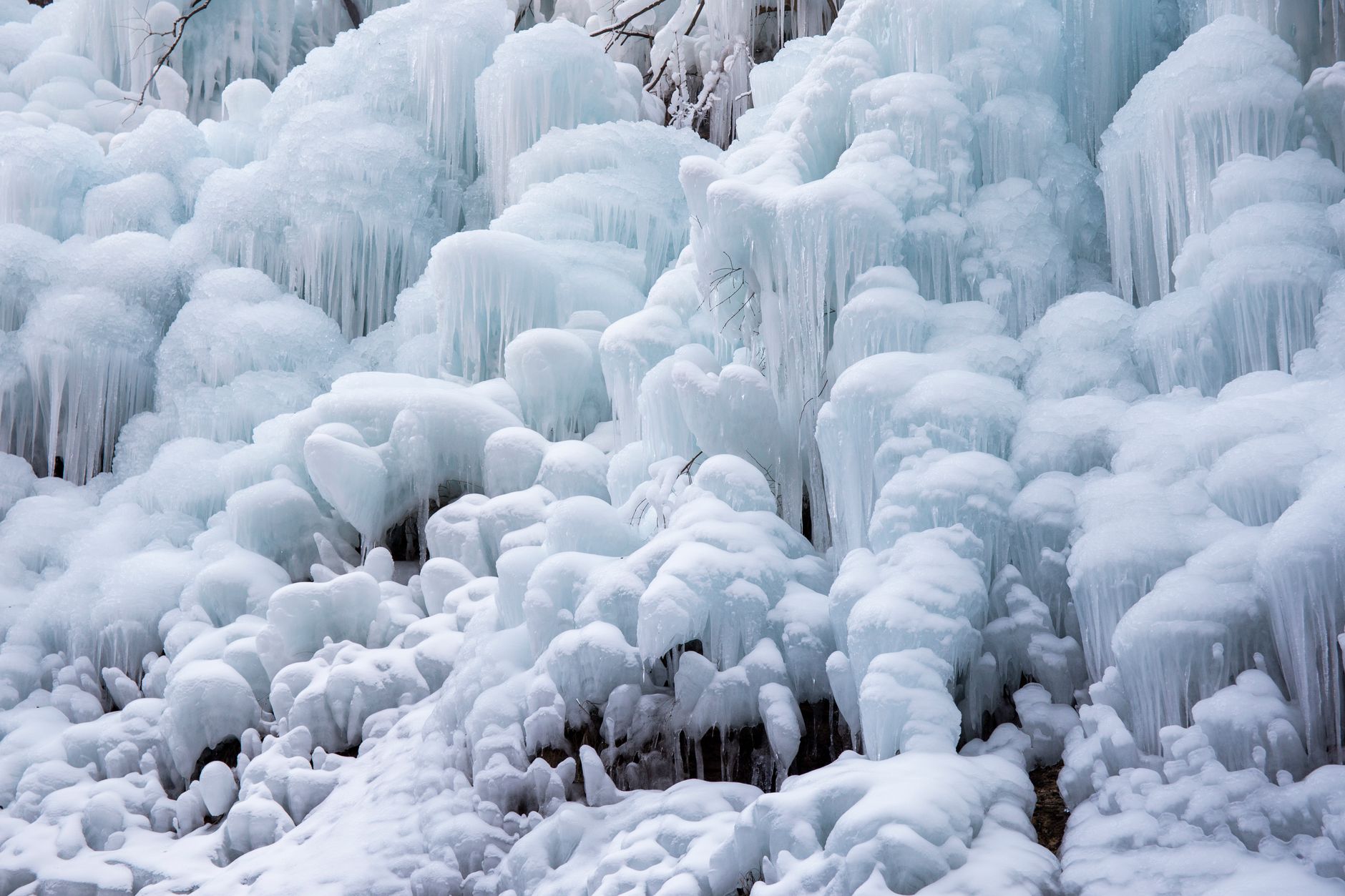 Bottles of vodka and whiskey sitting in a frosty freezer with ice crystals forming on the glass