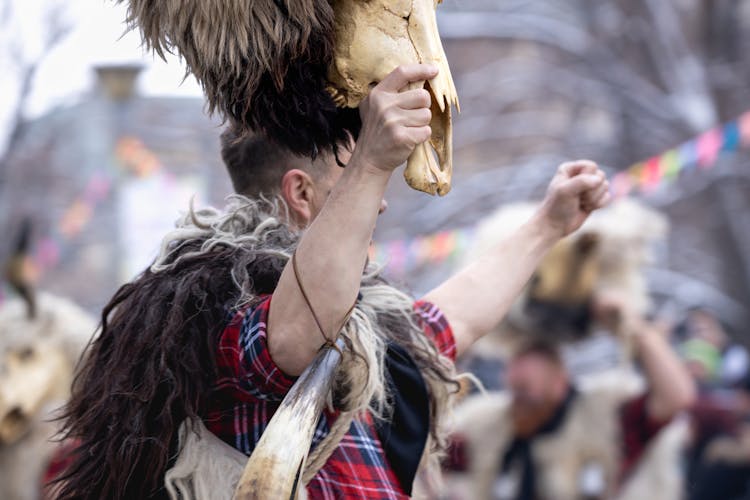 Man Wearing Furs Rising Animal Skull In Air