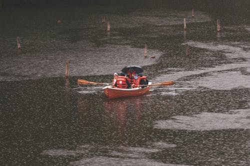 People on Boat on Lake in Rain