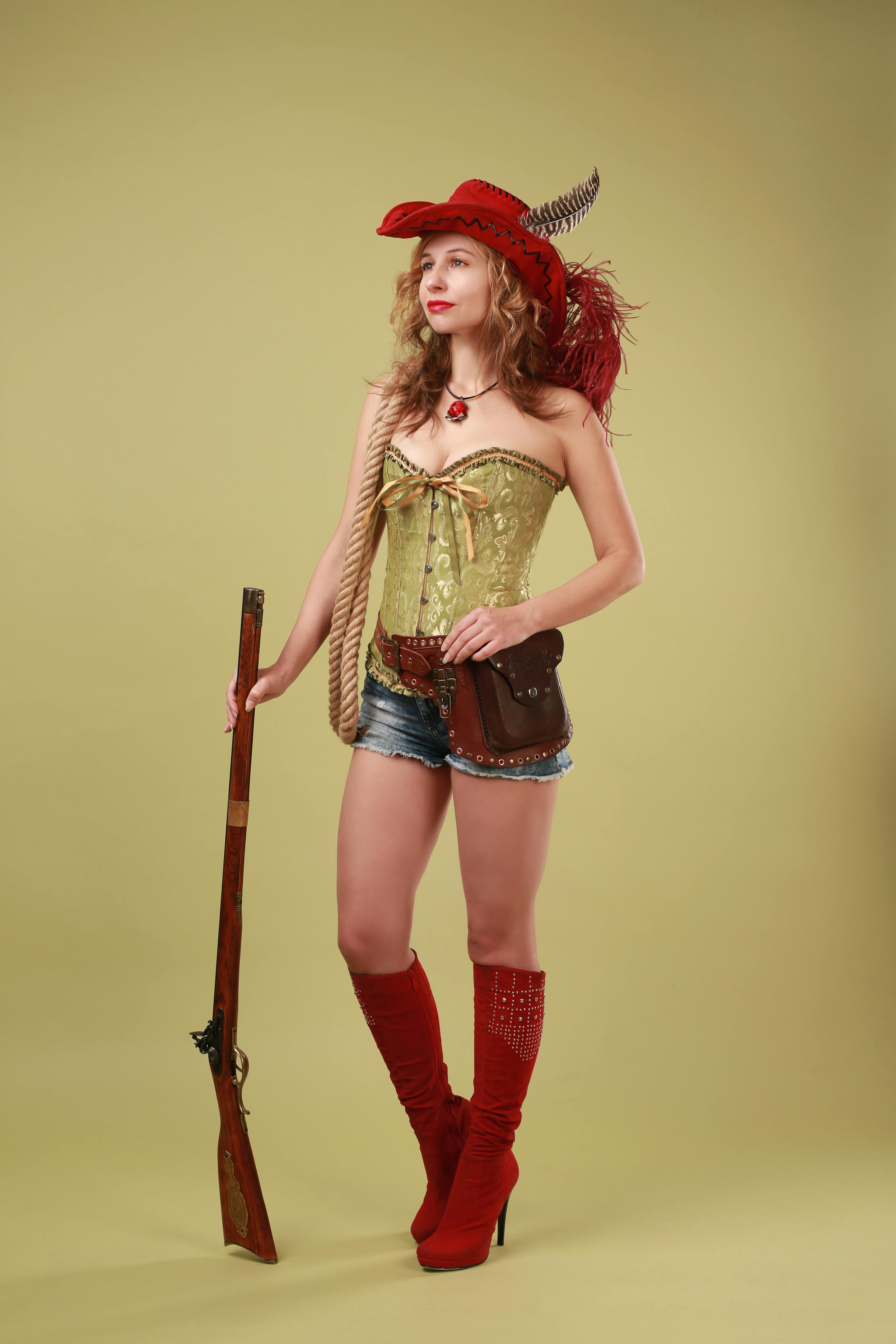 Woman in Jean Shorts and Green Corset Posing with Musket · Free Stock Photo
