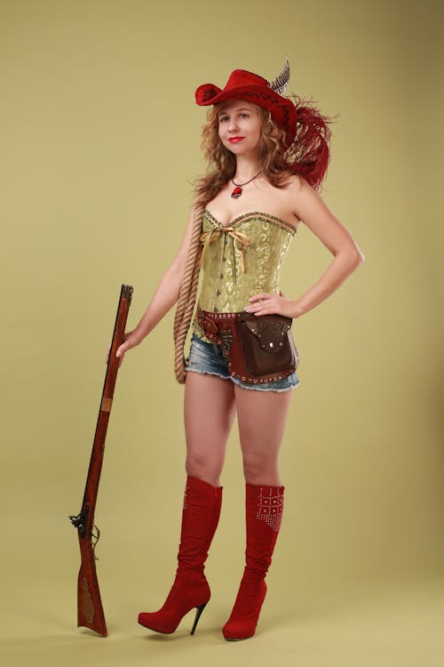 Woman in Red Boots and Hat Posing with Retro Musket