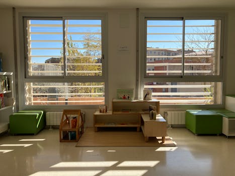 Sunny kindergarten reading area with bookshelves and seating in Barcelona, Spain.