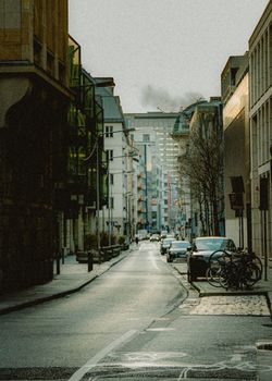 Charming urban street scene in Frankfurt, Germany, featuring cars and bicycles along a quiet road.