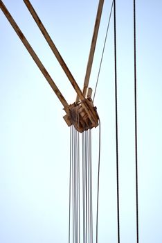 A detailed view of a crane pulley system with clear blue sky background in Fès, Morocco.