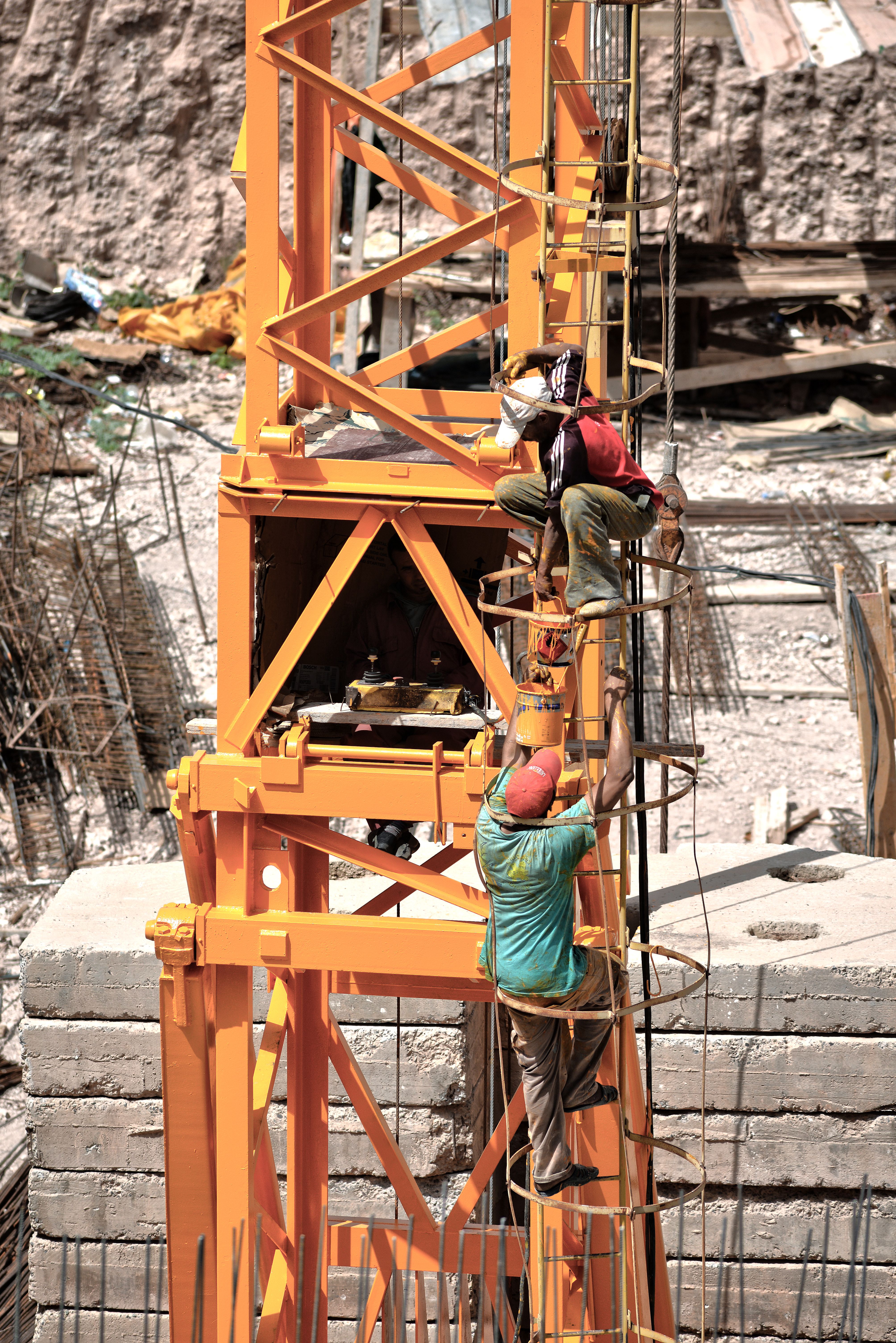 Workers climbing a construction tower on a building site