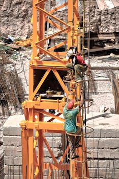 Workers climbing a construction tower in Fès, showcasing teamwork and safety.