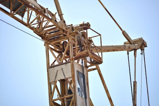 Close-up of a tower crane against a bright blue sky in Fès, Morocco, showcasing construction detail.
