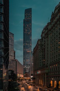A captivating view of towering skyscrapers lit up at dusk in a bustling city center, showcasing urban life.