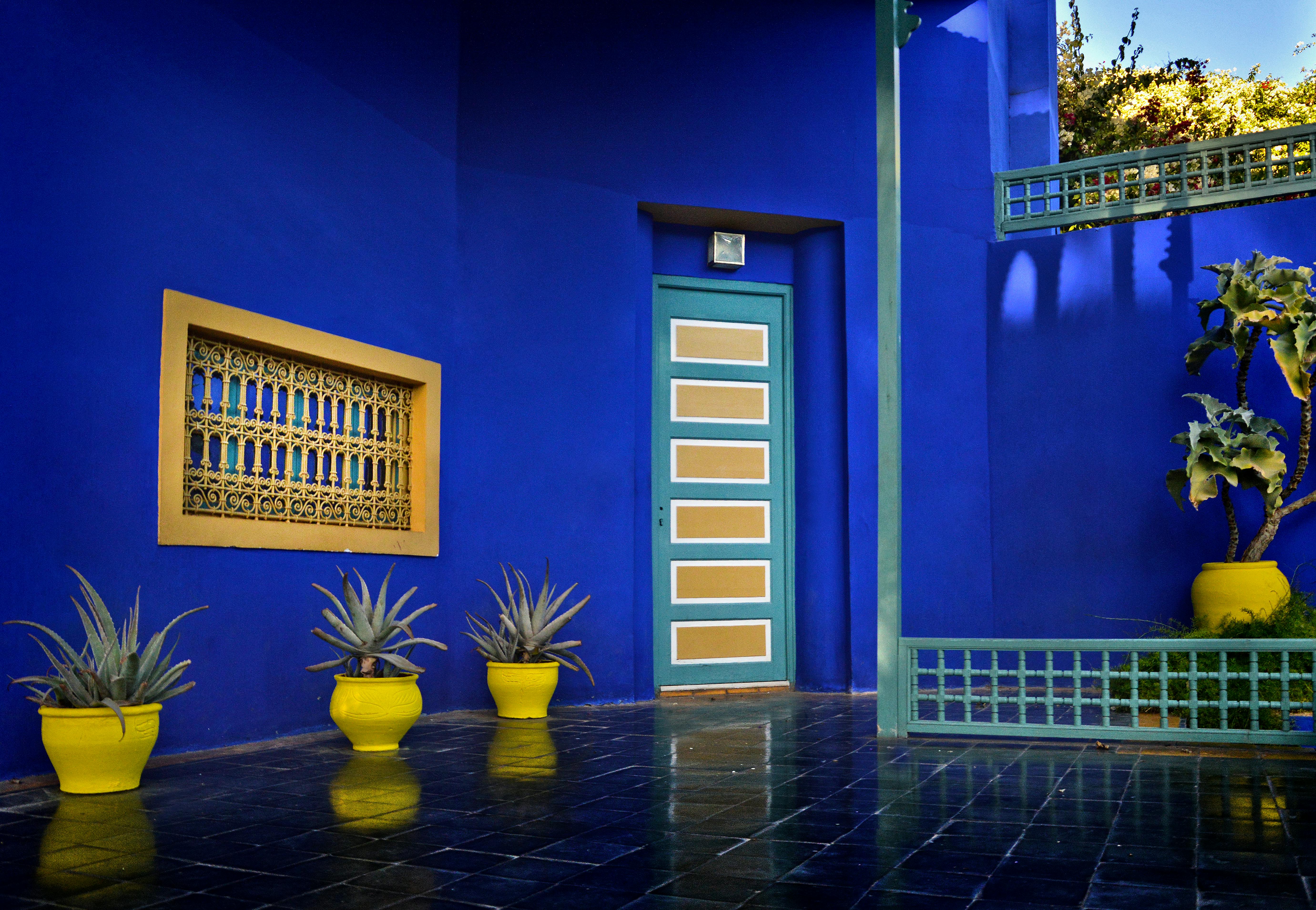 Things to Do in Marrakech: The Ultimate Travel Guide (2026) - Colorful Moroccan courtyard with blue walls and yellow planters in Marrakech. - Marrakech