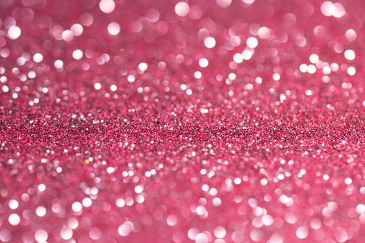 A vibrant pink glittery background with sparkling bokeh effects.