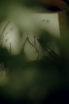 Dark and moody close-up of an artistic pen sketch partially obscured by shadows.