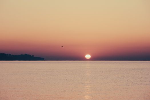 Beautiful sunset with a calm ocean, creating a serene and peaceful ambiance.