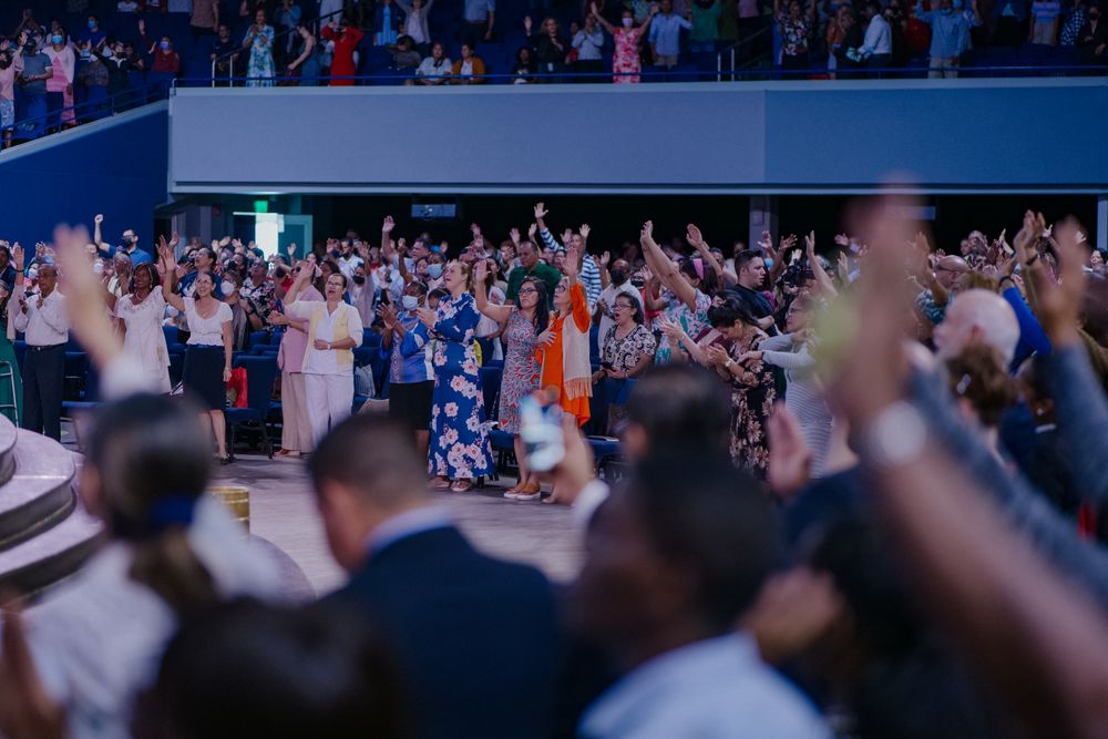 Crowd raising hands at an indoor event