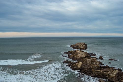 Free Capture of rugged rocks and waves at Zarautz beach on a cloudy day. Stock Photo