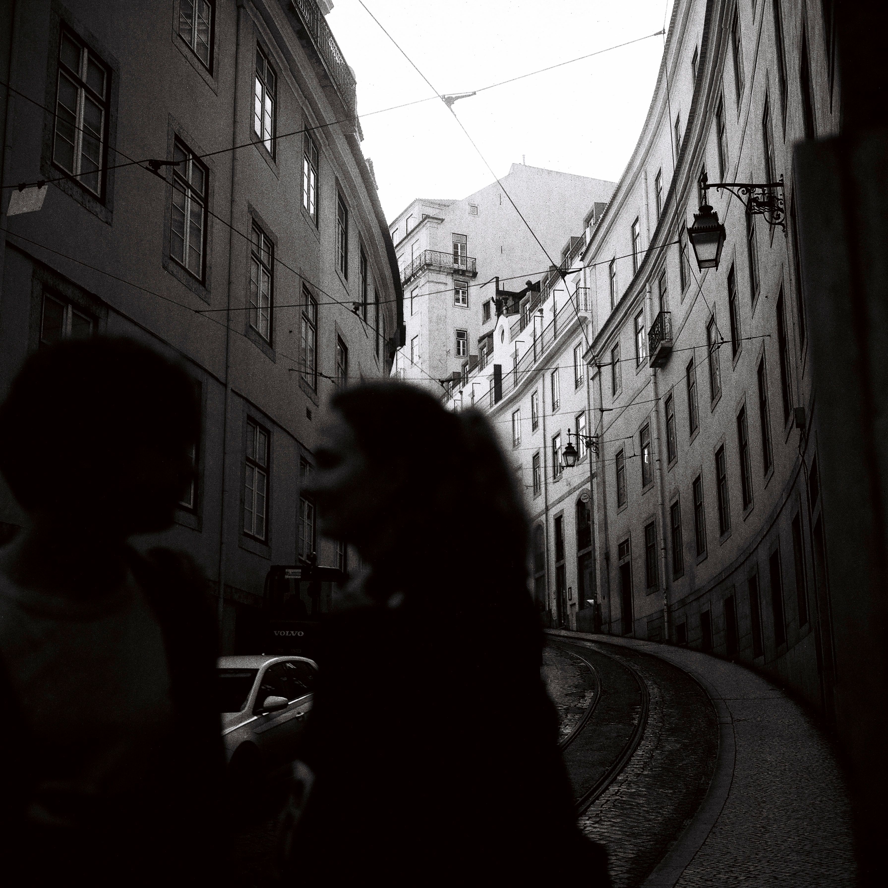 Woman Crossing a Street Between Buildings