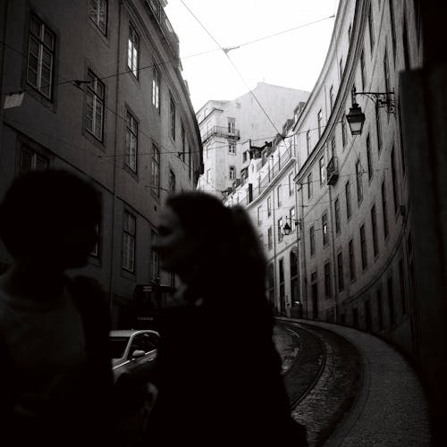 Woman Crossing a Street Between Buildings