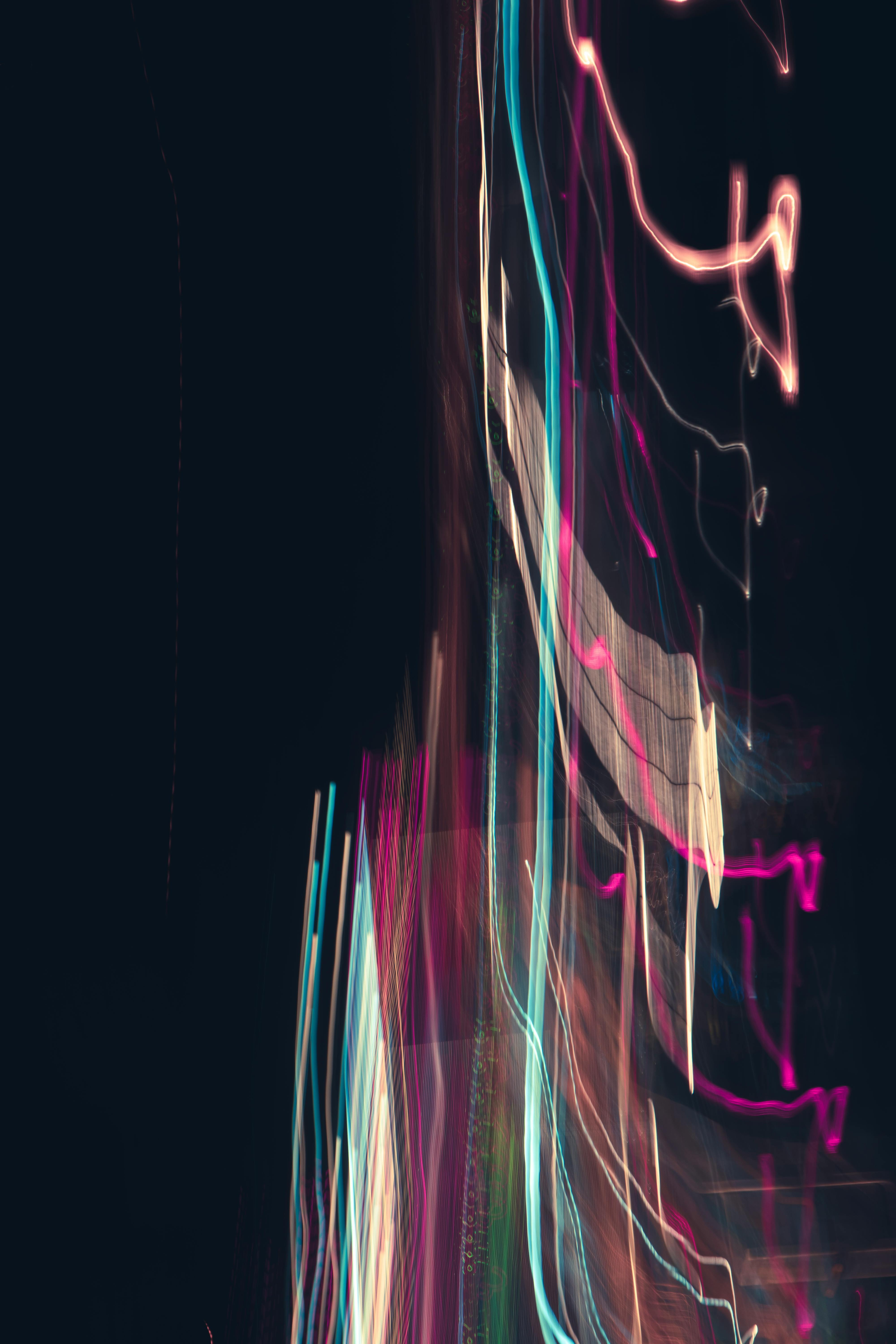 Vibrant light trails creating abstract shapes against a dark night sky.