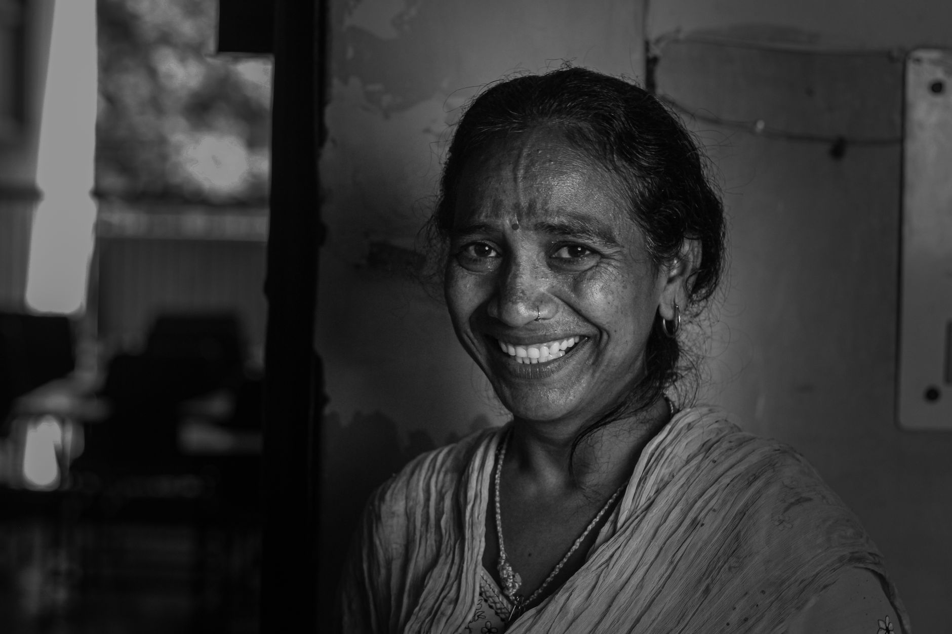 Captivating black and white portrait of a smiling senior Indian woman.