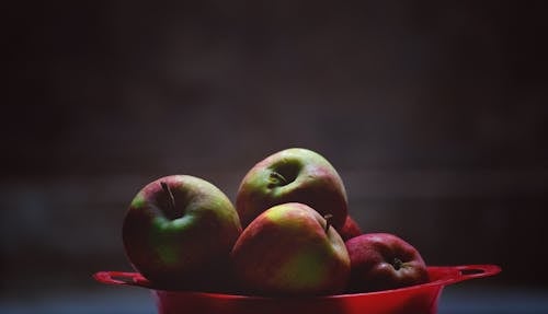 Green and Red Apple Fruits in Red Plastic Bowl