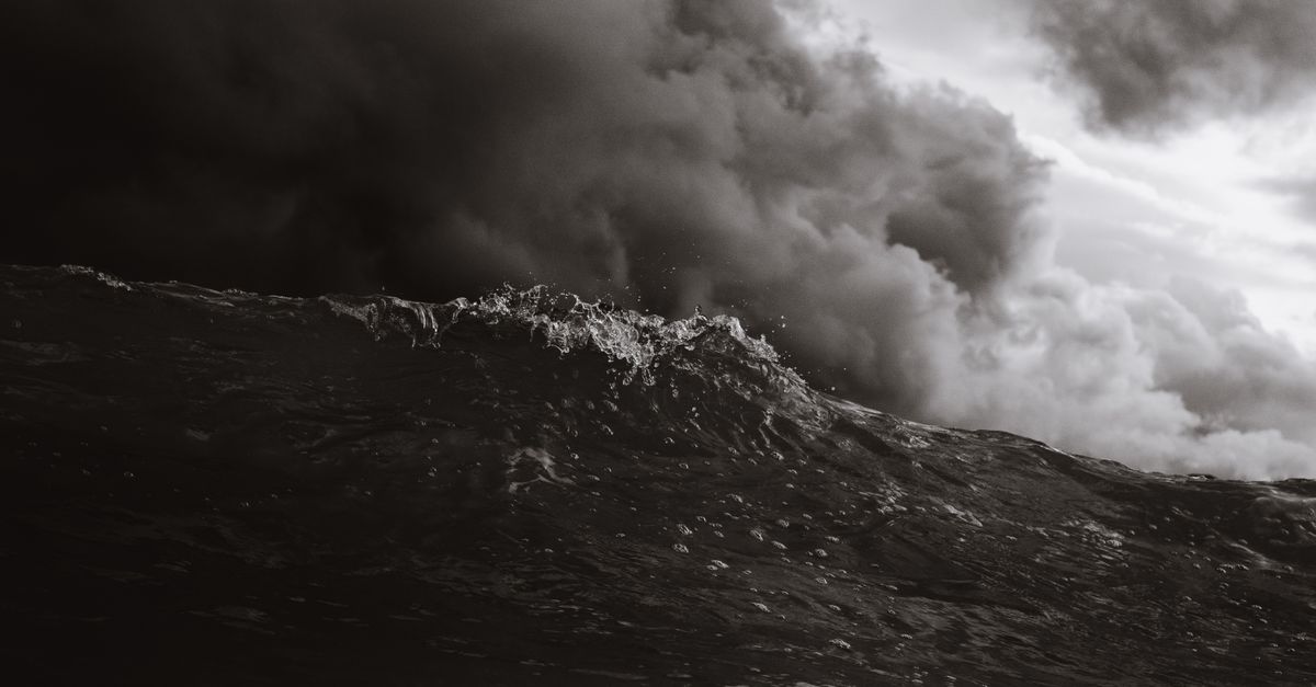 Rüyada Deniz Fırtınası Görmek - Rüya Tabiri ve Anlamı - Powerful ocean wave with storm clouds in monochrome, capturing nature's intensity.