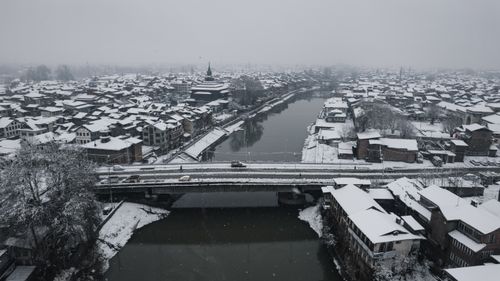 Free Aerial view of a snow-covered Srinagar cityscape featuring a historic bridge. Stock Photo