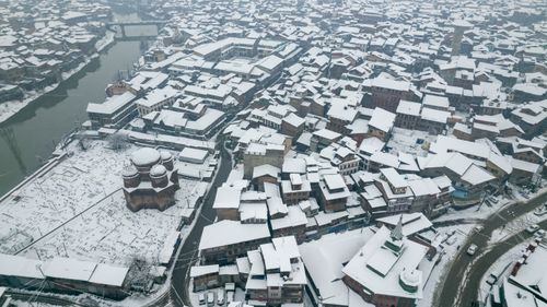Free Aerial view of snow-covered Srinagar buildings and river, showcasing winter cityscape. Stock Photo