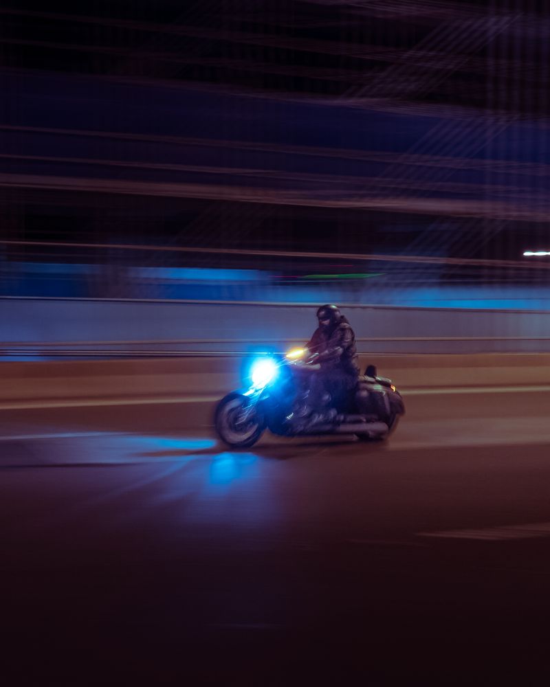 A motorcyclist speeds down a highway creating a dynamic motion blur effect