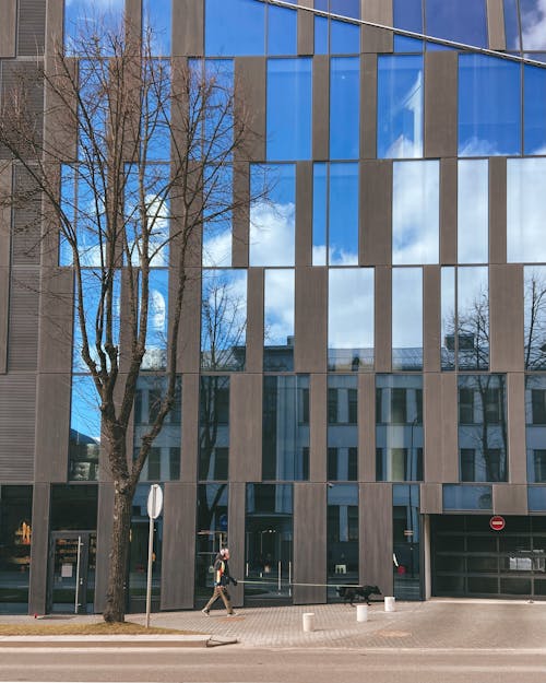 Person Walking near Modern Office Building