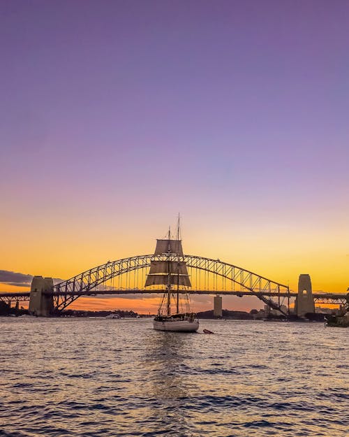 Zeilboot Voor Brug Onder Oranje Zonsondergang