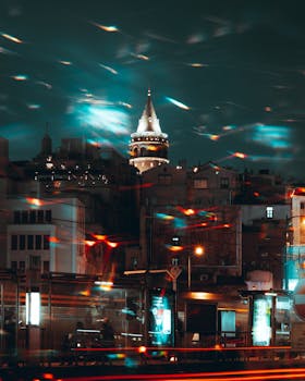 A captivating night scene of the illuminated Galata Tower with vibrant city lights in Istanbul, Turkey.