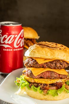 Close-up of a cheeseburger with a Coca Cola can, perfect for fast food themes.