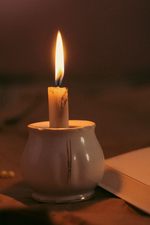 Free Close-up of a burning candle in a ceramic vase, creating a warm glow. Stock Photo