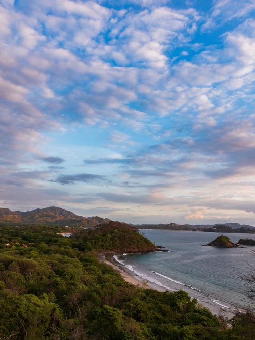 Free Breathtaking aerial view of Guanacaste, Costa Rica's lush coastline and serene sea under a vibrant sky. Stock Photo