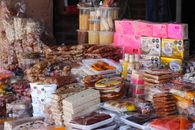 Vibrant display of traditional Mexican snacks at a bustling market stall.