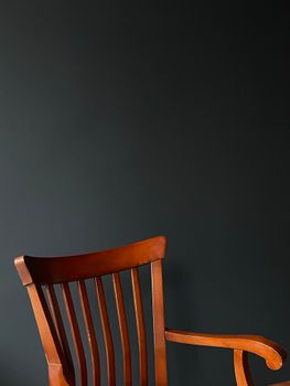 Elegant wooden chair on a black background with ample copy space.