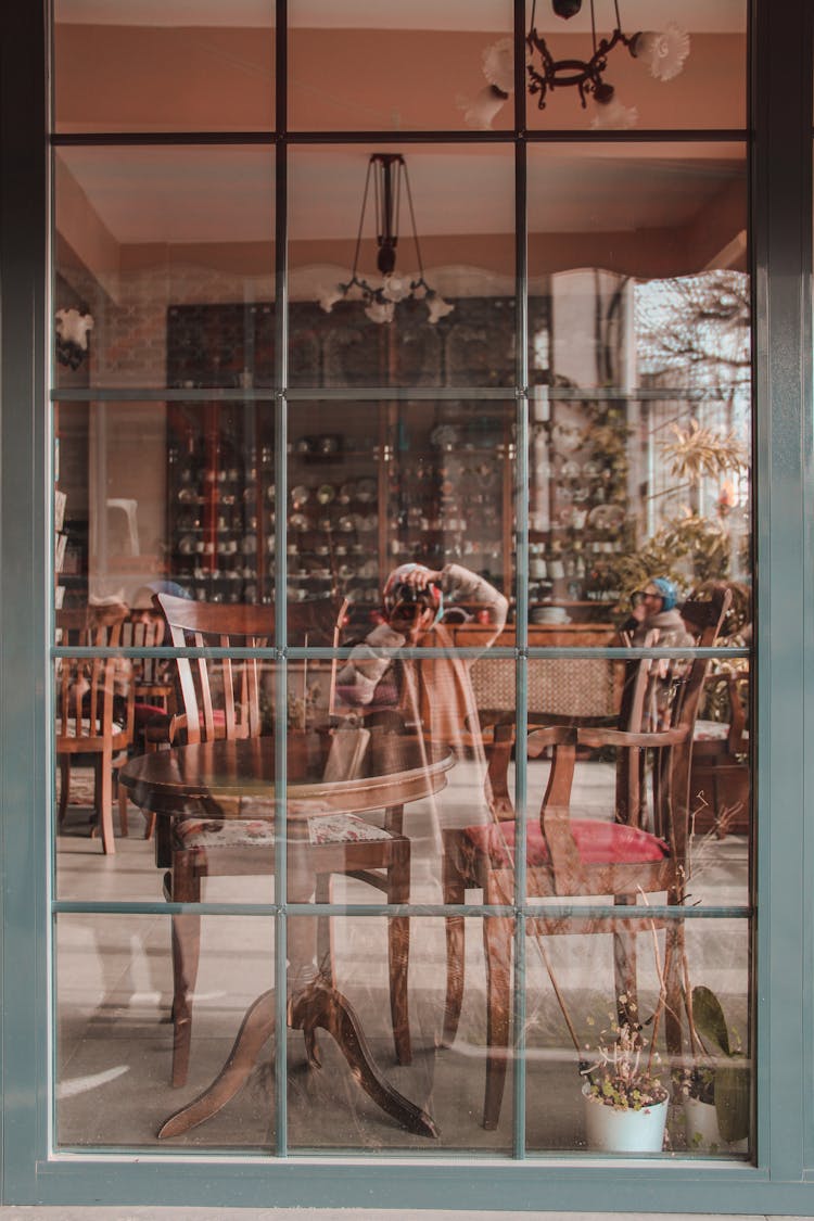 Reflection Of Photographing Woman In Restaurant Window