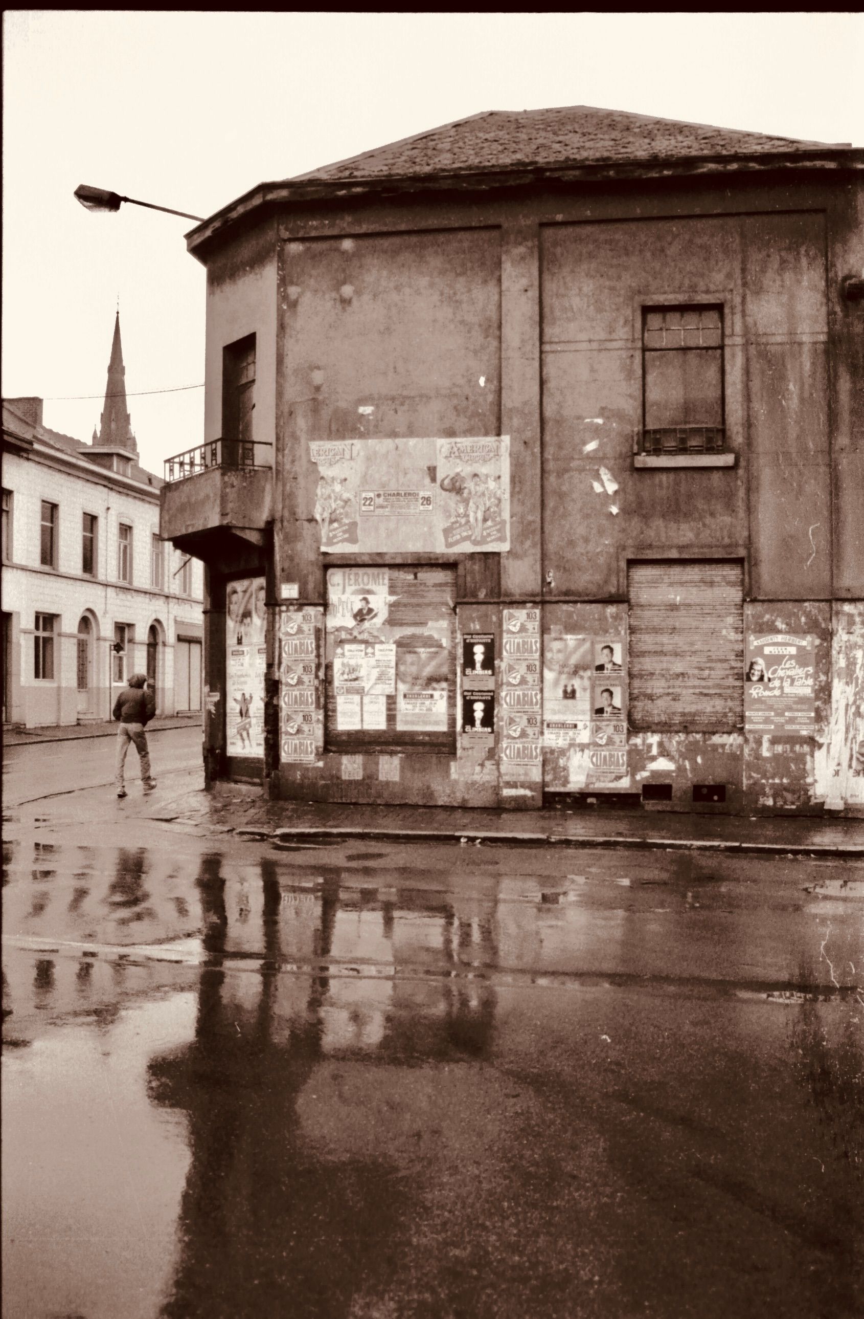 Free A nostalgic view of a vintage urban street on a rainy day with reflections. Stock Photo