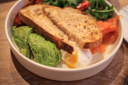 Delicious brunch dish featuring avocado, poached egg, and toast in a clean, minimalist setting.