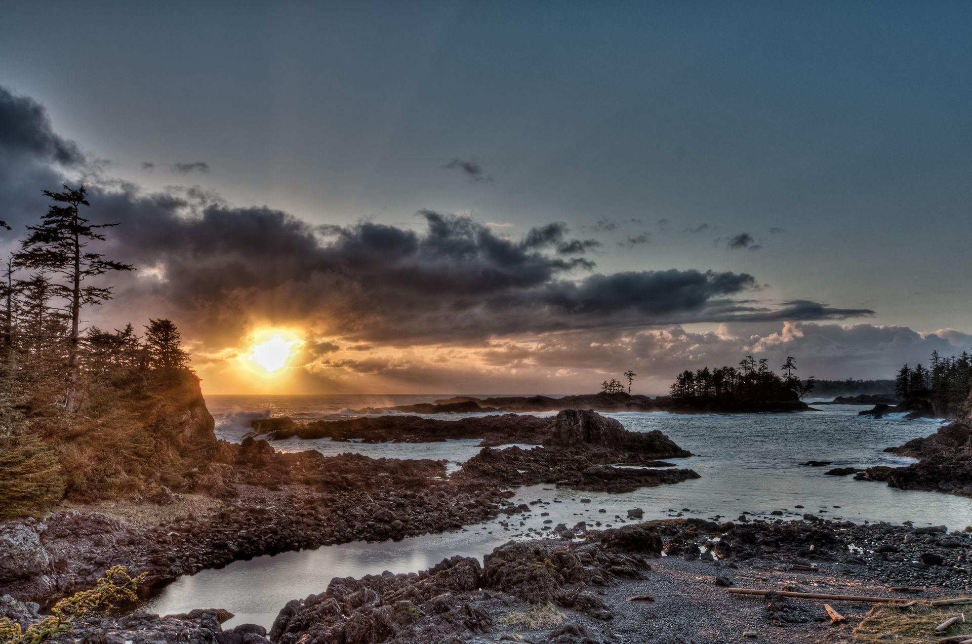 Dramatic sunrise over a rocky coastal landscape in Ucluelet, British Columbia, Canada.