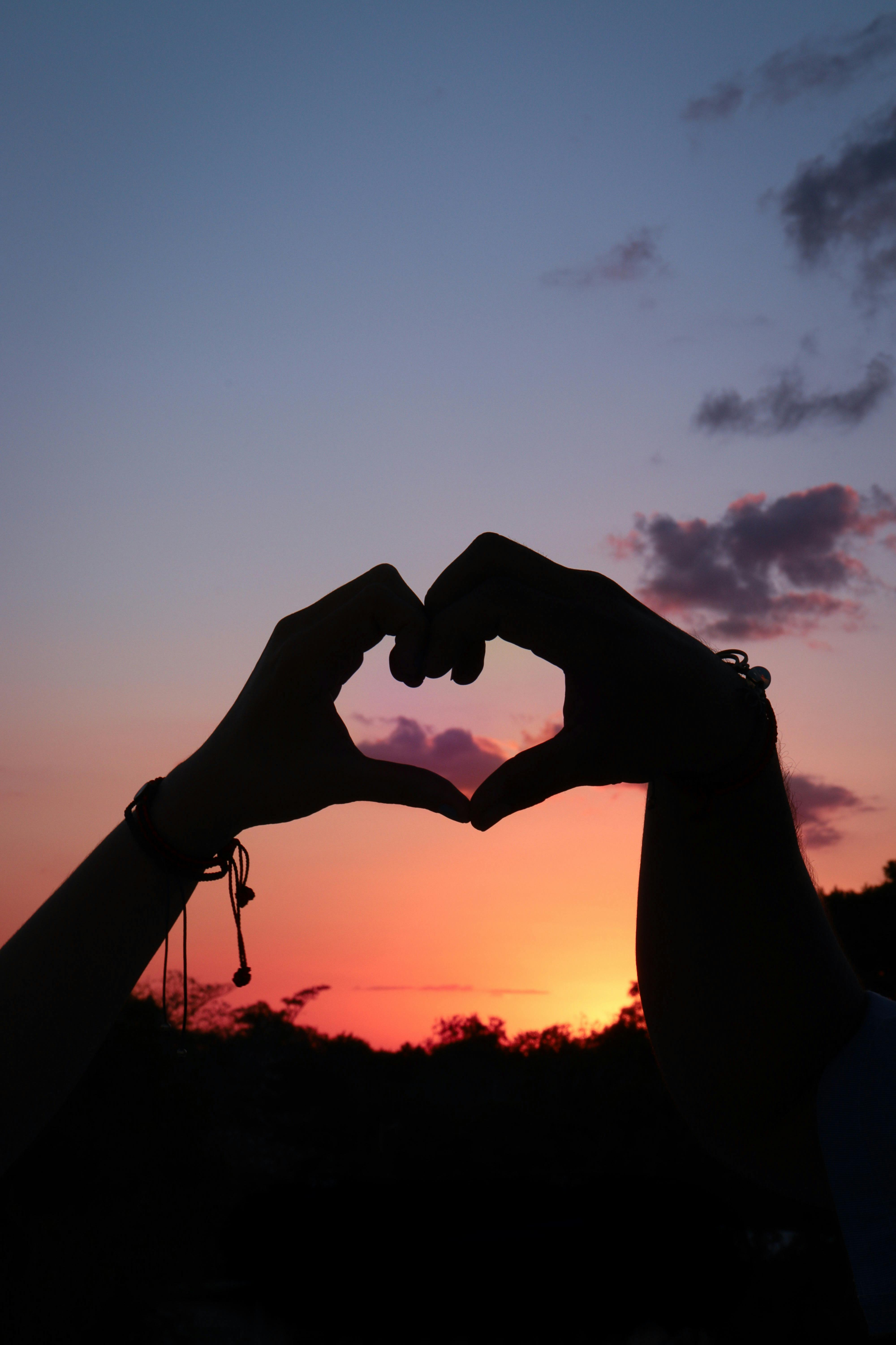 two hands making a heart logo